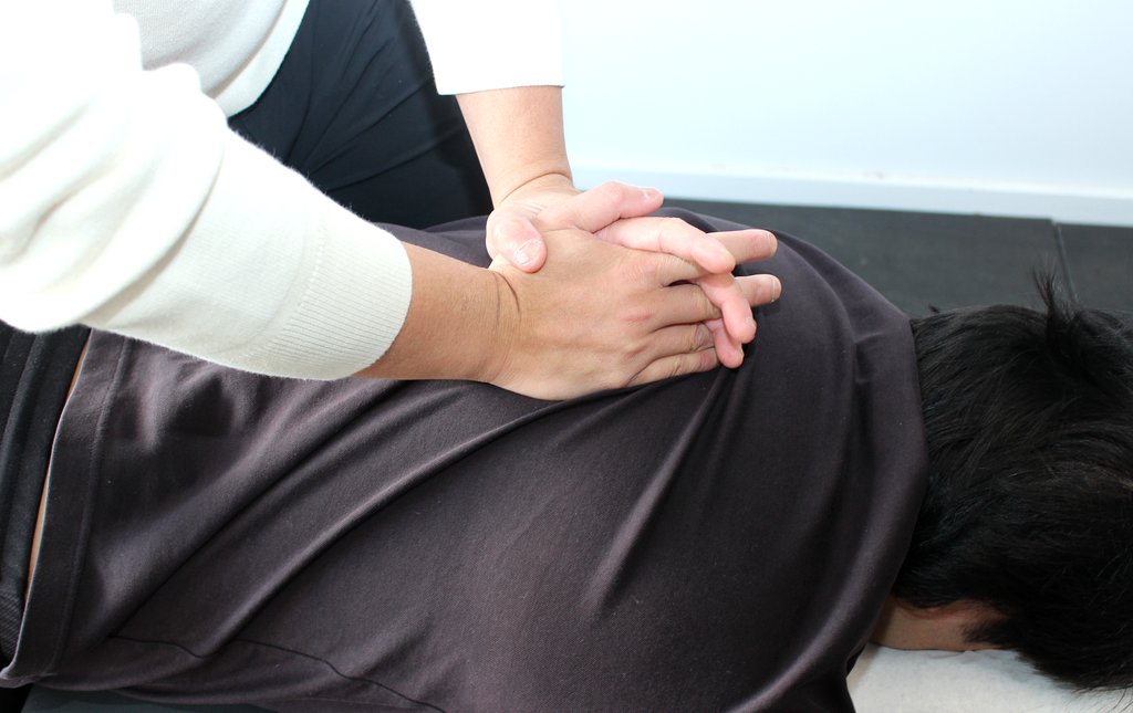 Dr Justin Nguyen performing a chiropractic back adjustment during an active care appointment at APEX. Chiro Gregory Hills.