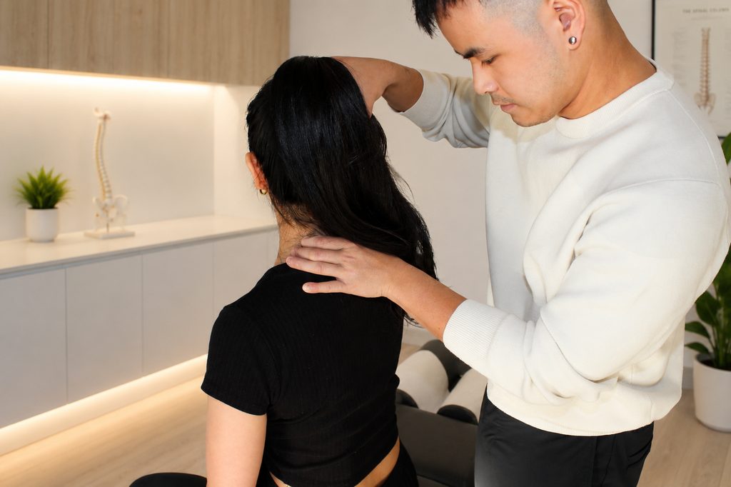 Chiropractor performing a spinal assessment with a patient at APEX. Chiro Gregory Hills.